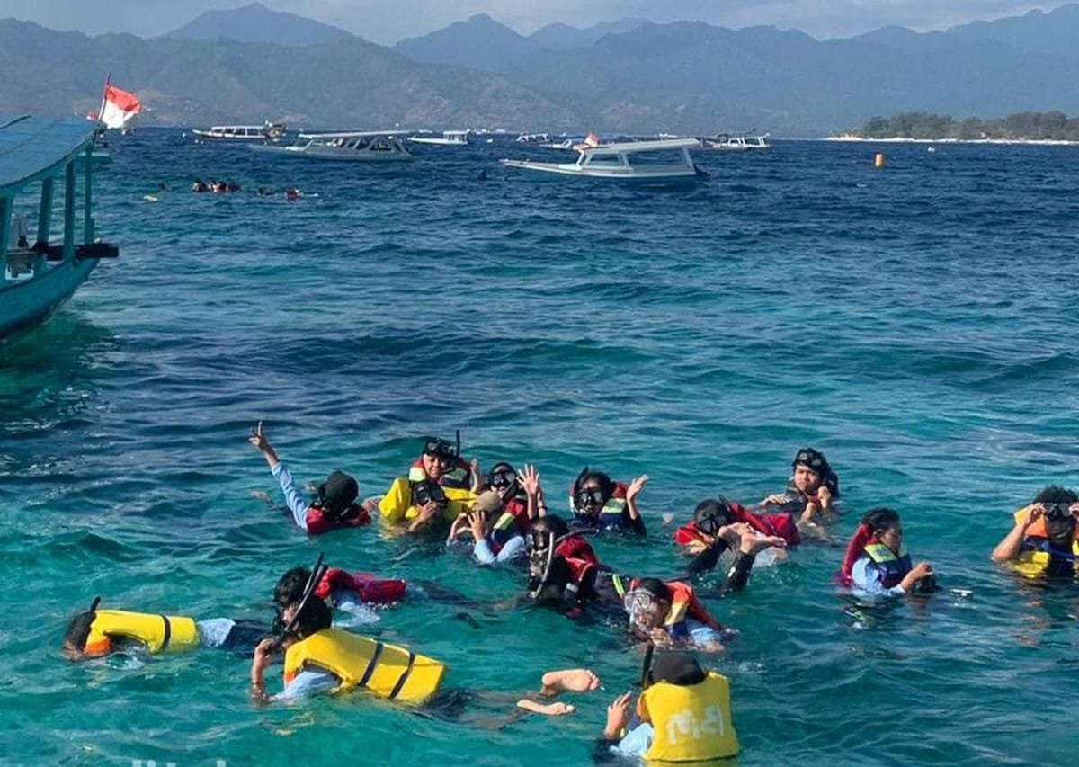 Shared snorkeling boat above coral garden, Gili Islands
